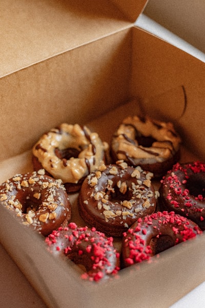 Box with brown and pink doughnuts
